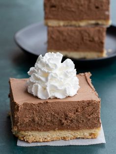 two slices of chocolate cheesecake with whipped cream on top