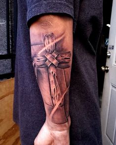 a person with a cross tattoo on their arm