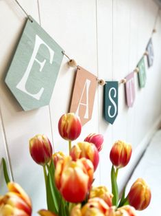 a vase filled with tulips sitting on top of a table next to a sign