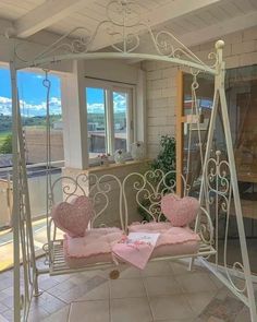 a white swing with two pink hearts on it in the middle of a living room