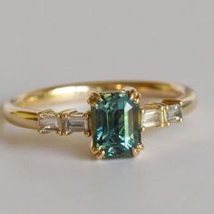 an emerald ring with three baguets on the side