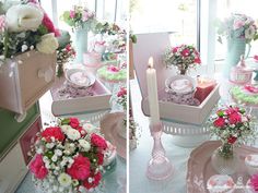 the table is set with pink and white flowers in vases, plates and candles