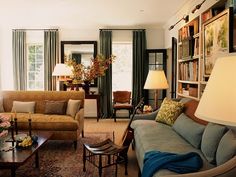 a living room filled with furniture and lots of books on the shelves in front of them