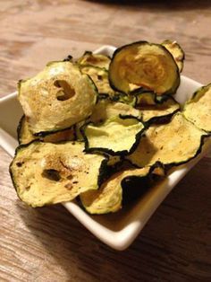 sliced zucchini sitting on top of a white plate next to a wooden table