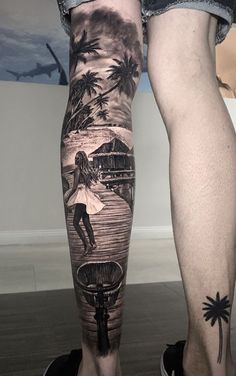 a person with a tattoo on their leg standing in front of a wall and palm trees