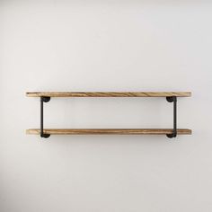 two wooden shelves on the wall with black metal brackets and one shelf is made out of wood