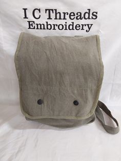 Customizeable olive-grey canvas bag with snap closures on the front. Includes small pockets on the inside and a large storage area. Adjustable straps have clip on closures. Item price includes customization. Limited to 2 inch tall monogram or 1 inch tall first name. Gray Rectangular Canvas Bag For School, Rectangular School Satchel With Canvas Lining, Military Style Bags With Pockets For Everyday Use, Military Style Everyday Bag With Pockets, Khaki Rectangular Canvas Bag For School, Khaki Canvas School Bag With Removable Pouch, Khaki Canvas Bag For School, Khaki Canvas School Bag, Military Style Canvas Bag With Pockets