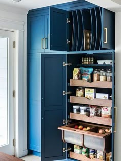 an organized pantry with blue cabinets and drawers