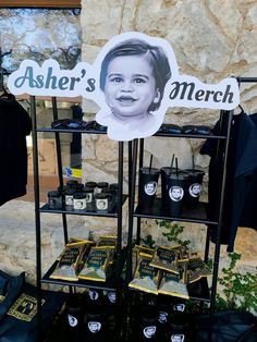 there is a sign that says asher's merch on the shelf next to other items