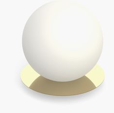 a white ball sitting on top of a gold plate