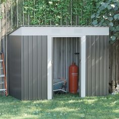 a red fire extinguisher sitting in the corner of a shed next to a ladder