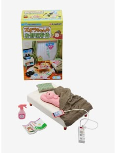 the doll is laying on her bed next to it's packaging