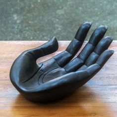 a sculpture of a hand on a wooden table