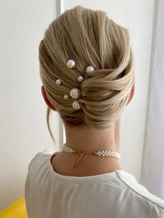 a woman with blonde hair and pearls in her hair