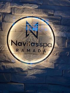 an illuminated sign on the side of a brick wall that reads navigas spa ramada