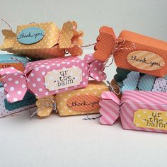 several small boxes with tags on them sitting next to each other, all decorated in different colors and patterns