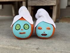 two orange and blue painted pumpkins with faces on them