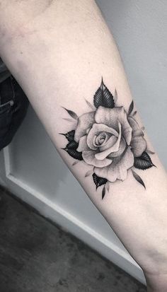 a black and white rose tattoo on the arm