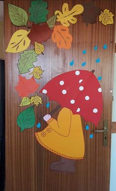 the door is decorated with leaves and an umbrella in the shape of a girl holding an umbrella