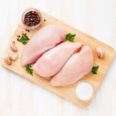 raw chicken breast on cutting board with spices and seasoning - stock photo - images