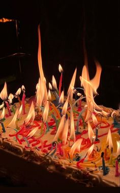 the birthday cake is decorated with candles and streamers