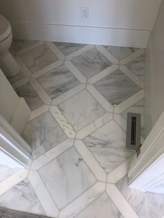 a bathroom with marble flooring and white walls