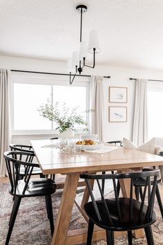 a dining room table with four chairs and a bowl of fruit on top of it