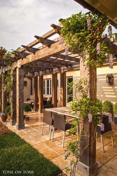 an outdoor dining area with wooden pergols and potted plants on the patio