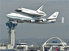 two planes flying in the air near each other with a space shuttle on top of them