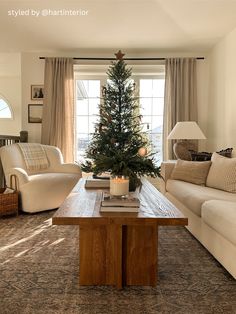 a living room filled with furniture and a christmas tree on top of a coffee table