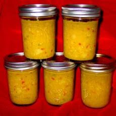 four jars filled with yellow colored food sitting on a red cloth