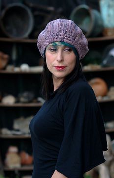 a woman wearing a purple hat standing in front of shelves