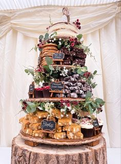 a wedding cake made out of cupcakes and pastries on a tree stump