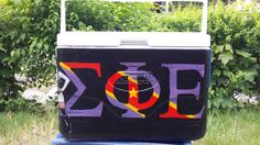 a cooler with the word zoo painted on it in front of some bushes and trees