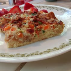 a slice of quiche on a plate with strawberries