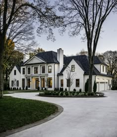 a large white house surrounded by trees and grass