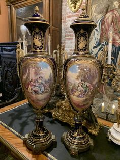 two large vases sitting on top of a table