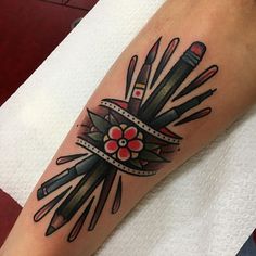 a tattoo design with knives and flowers on the arm, in black and grey colors