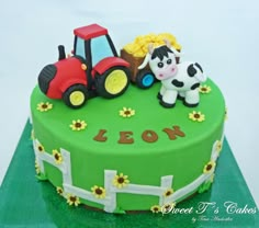 a birthday cake with a tractor and cow on it