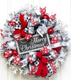 a christmas wreath with red, white and black bows on it that reads merry christmas