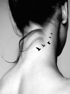 a woman's neck tattoo with birds on her left side and behind the neck