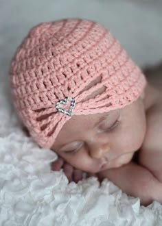 a newborn baby wearing a pink crochet hat