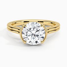 a yellow gold engagement ring with a round cut diamond in the center, on a white background