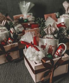 two mugs with christmas decorations are sitting in small wooden boxes