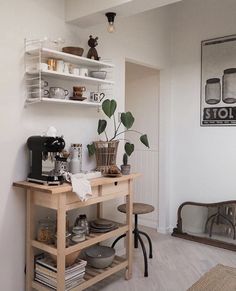 a kitchen with white walls and shelves filled with dishes, cups, and other items