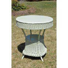 a white wicker table sitting in the grass