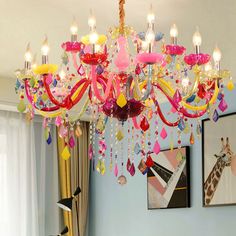 a pink chandelier hanging from the ceiling in a room with pictures on the wall