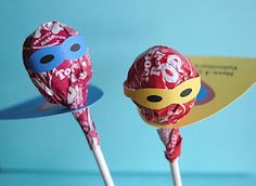 two candy lollipops sitting on top of each other in front of a blue background