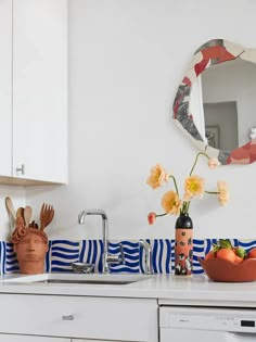 a kitchen with white cabinets and blue and white striped wallpaper on the counter top