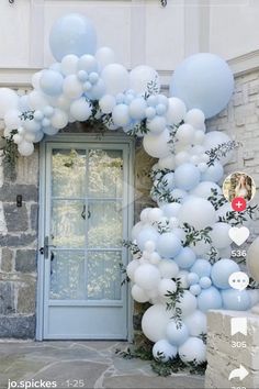 blue and white balloons are attached to the front door of a house with an arch